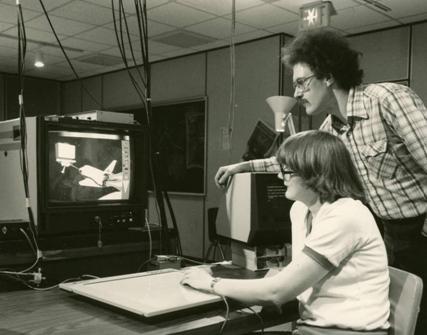 An instructor (John Beatty) and student work on a graphics project.